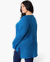 A woman wearing a bright blue ribbed knit sweater, shown from a side-back angle against a plain white studio background.