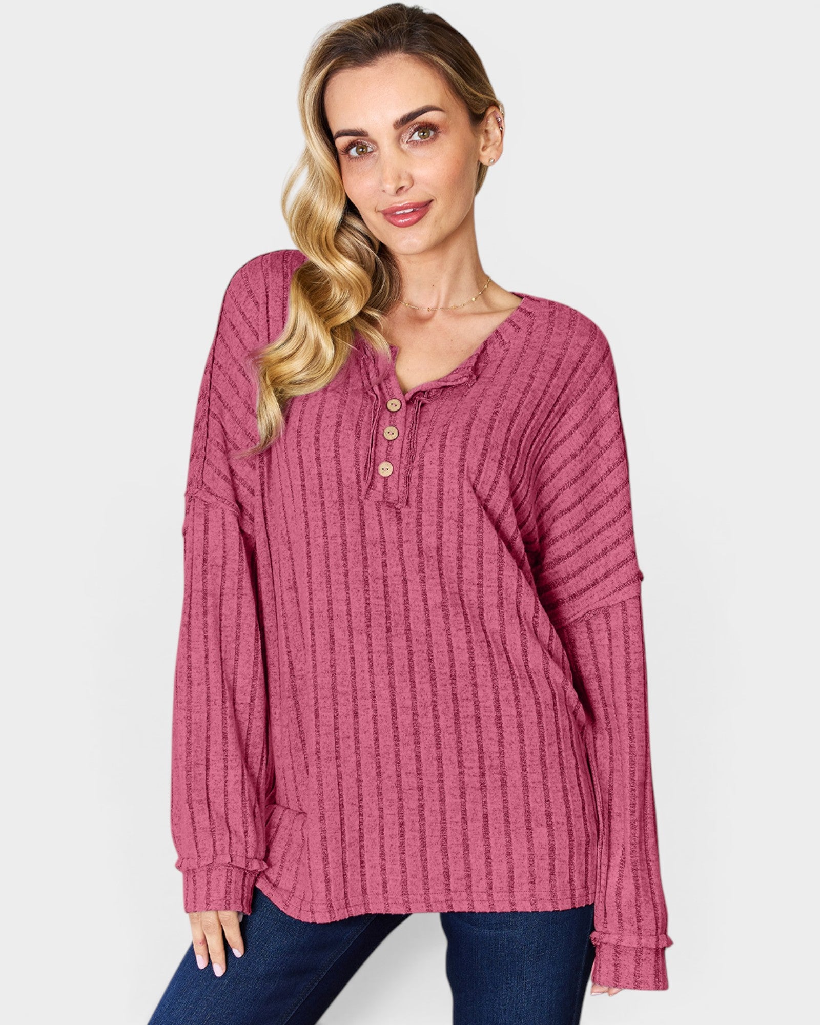 Woman wearing a pink textured long-sleeve top on a white background