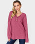 Woman wearing a pink textured long-sleeve top on a white background