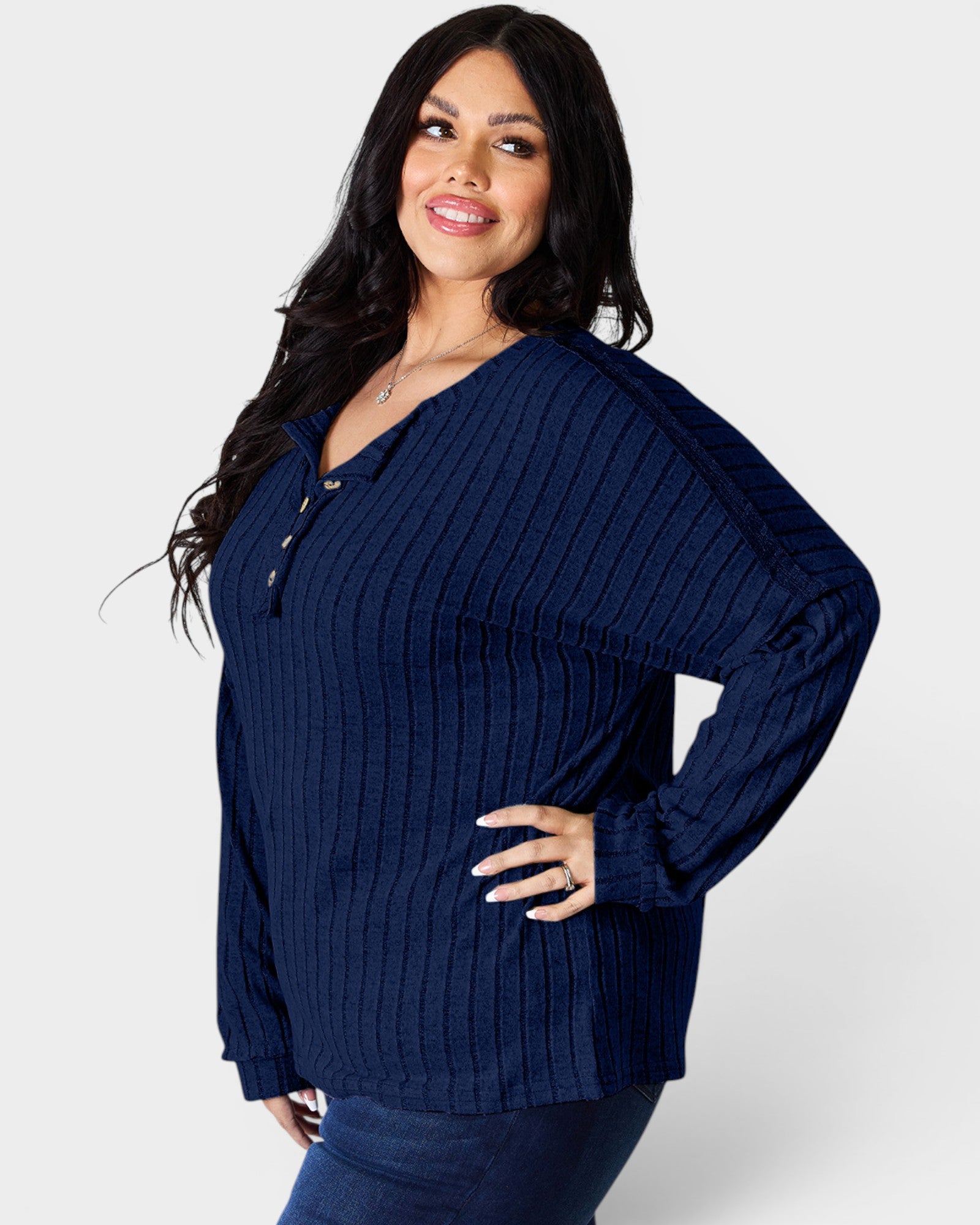 Woman wearing a navy blue ribbed sweater on a white background