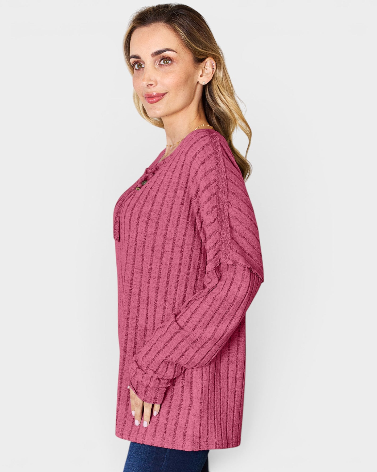 Woman wearing a pink textured long-sleeve shirt against a white background