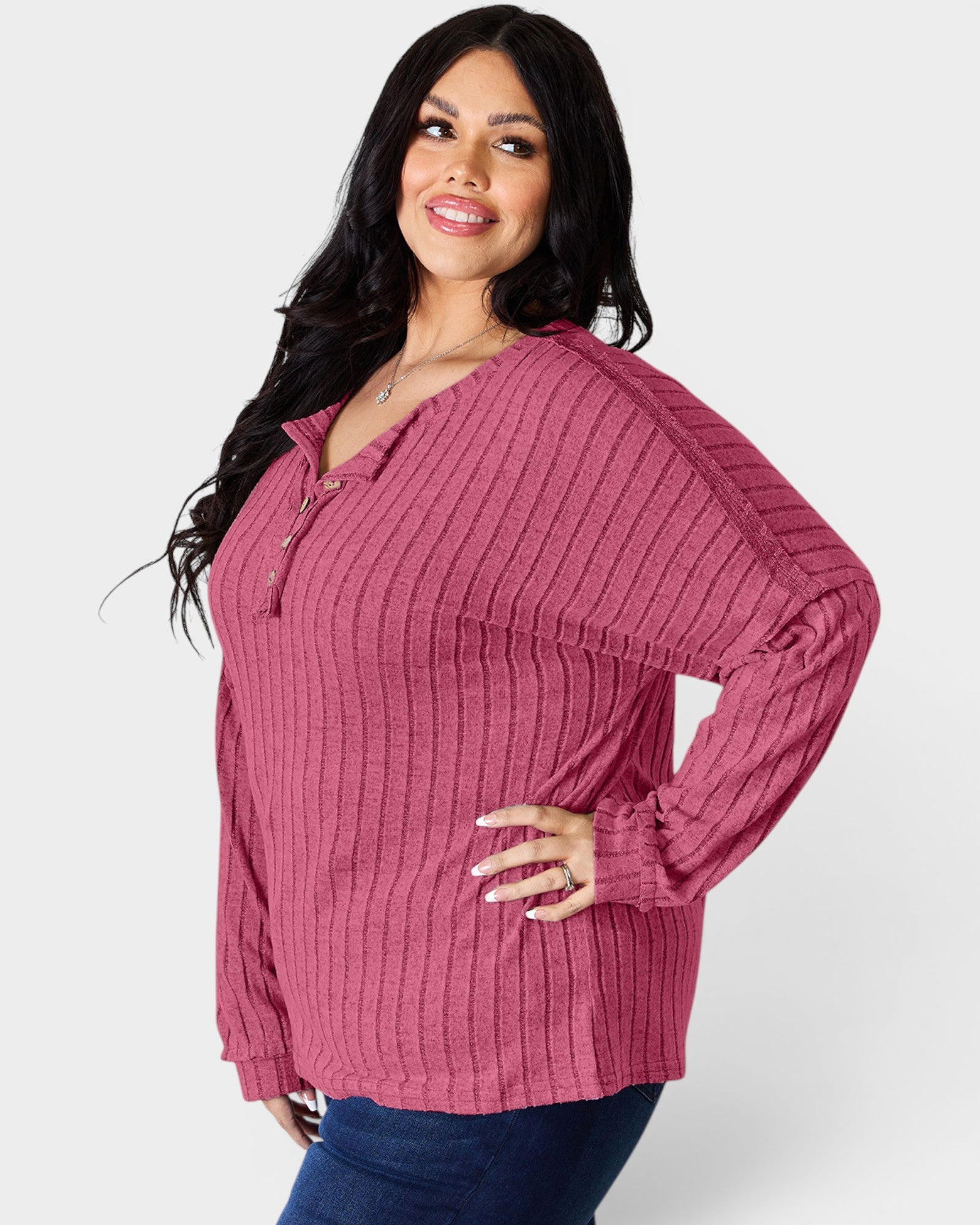 Woman wearing a pink ribbed sweater on a white background