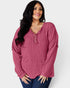 Woman wearing a ribbed pink long-sleeve top against a white background