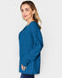 Woman wearing a blue ribbed sweater against a white background