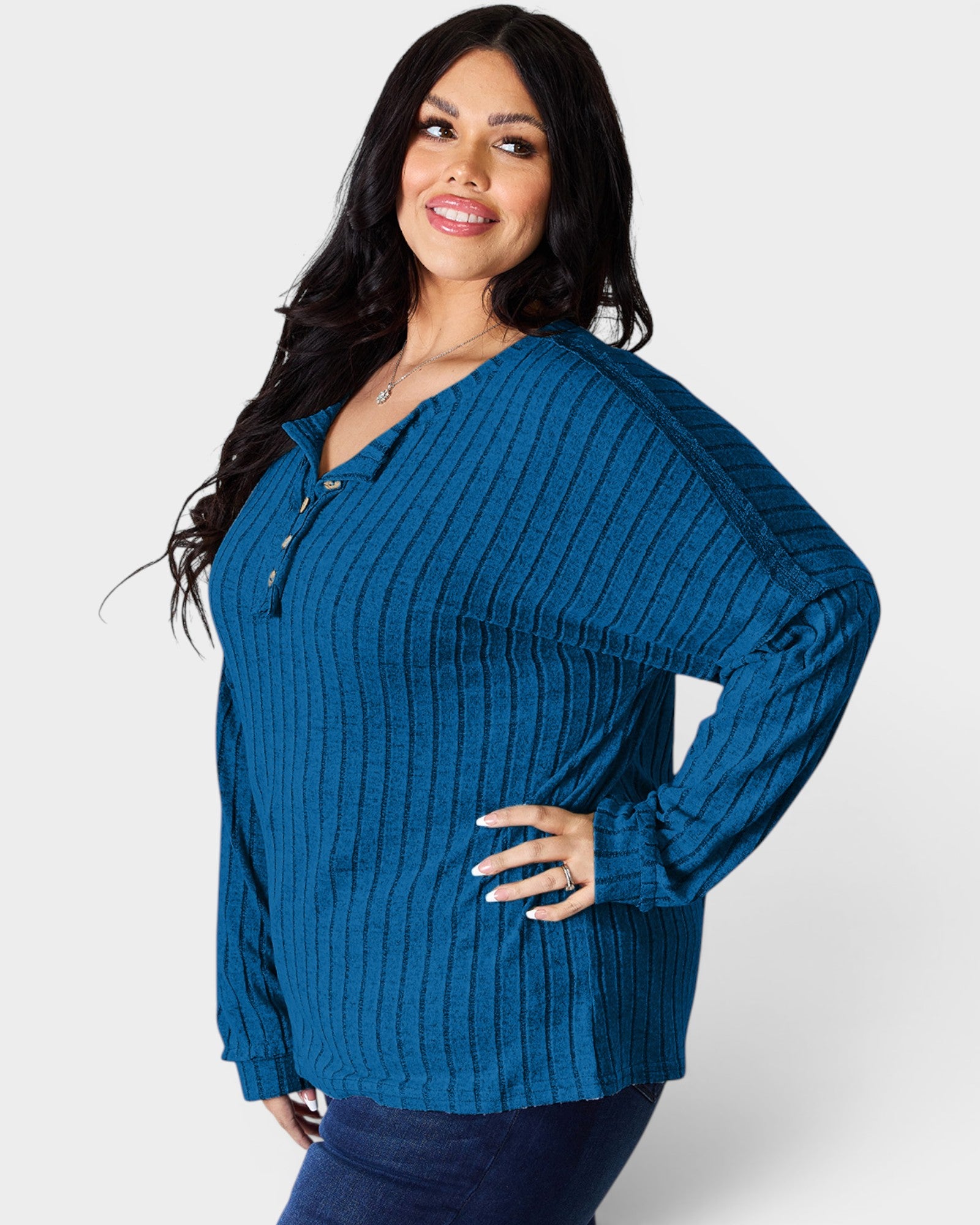 Woman wearing a blue ribbed sweater on a white background