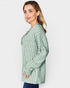 Woman wearing a green striped shirt against a white background