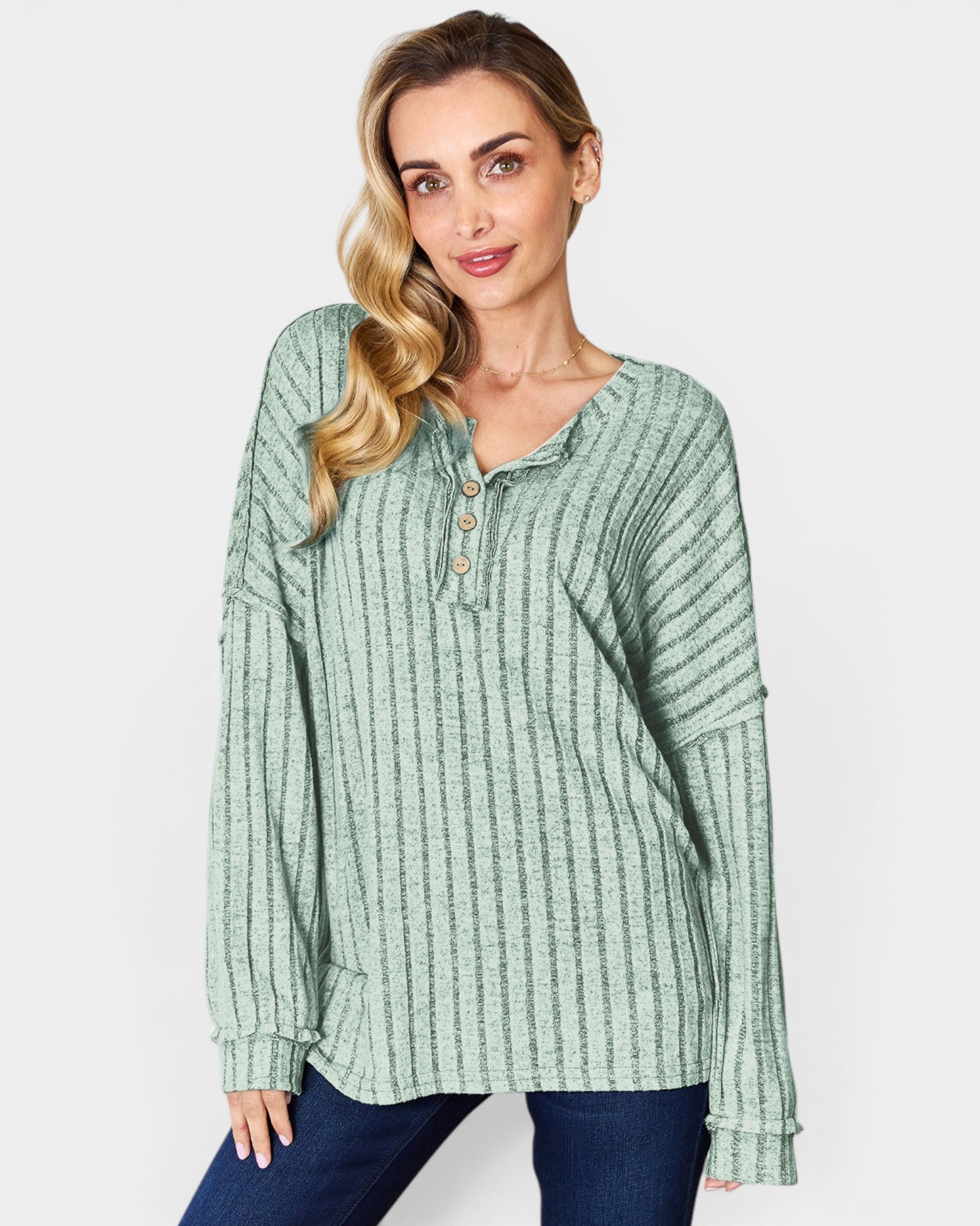 Woman wearing a green striped long-sleeve shirt on a white background