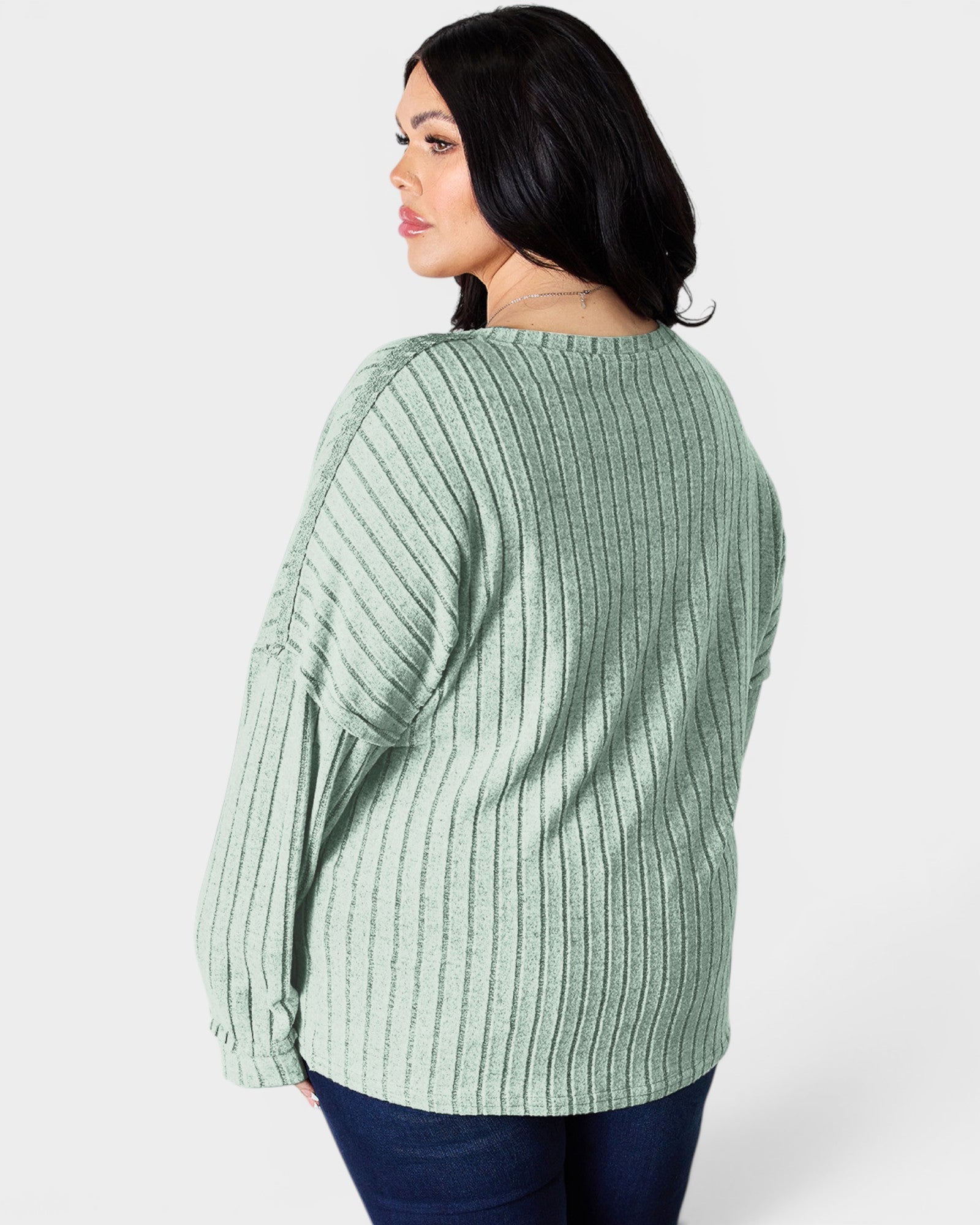 Woman wearing a green ribbed sweater on a white background