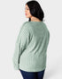 Woman wearing a green ribbed sweater on a white background
