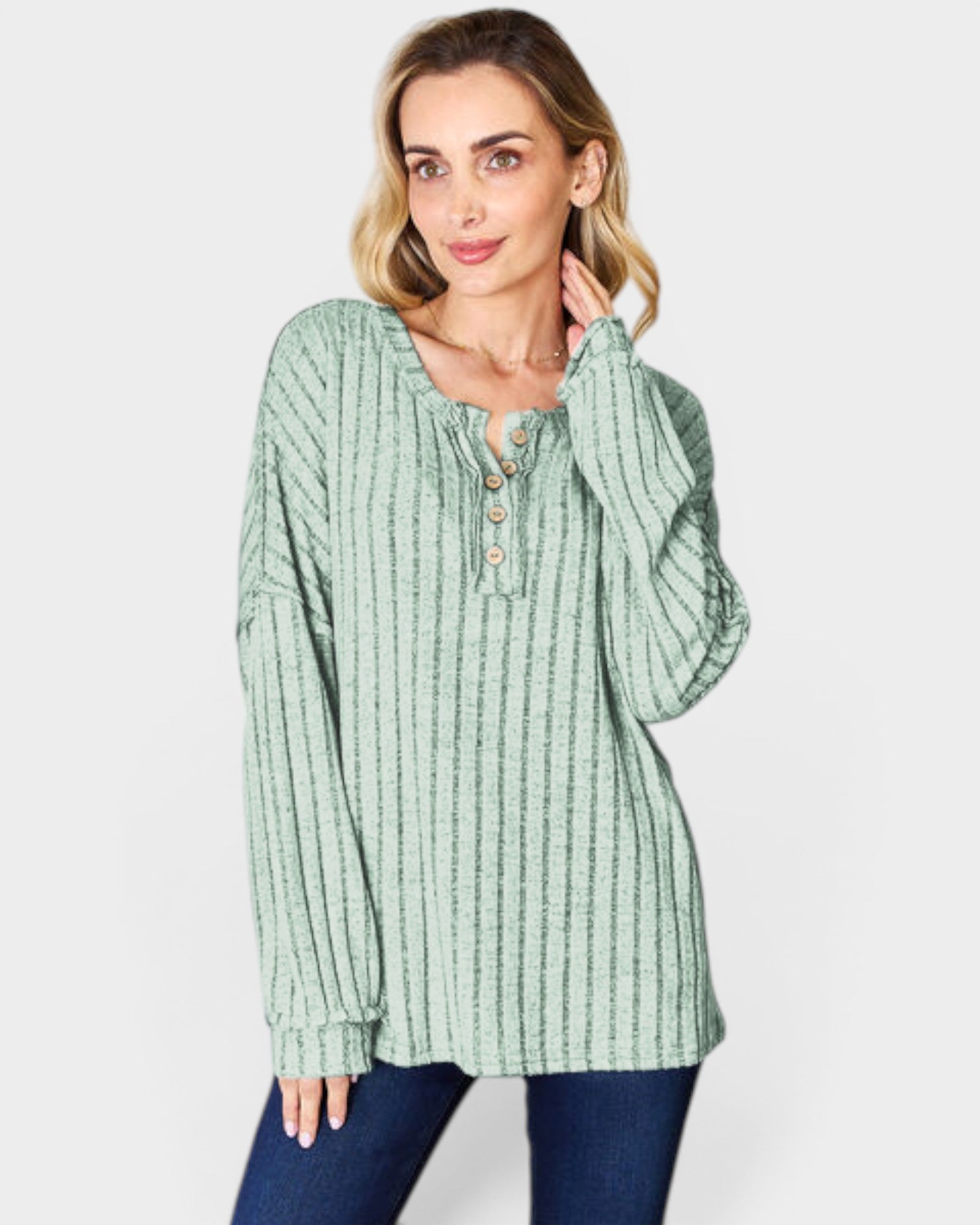 Woman wearing a green ribbed long-sleeve top on a white background