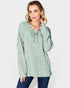 Woman wearing a green ribbed long-sleeve top on a white background