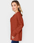 Woman wearing a rust-colored ribbed sweater on a white background