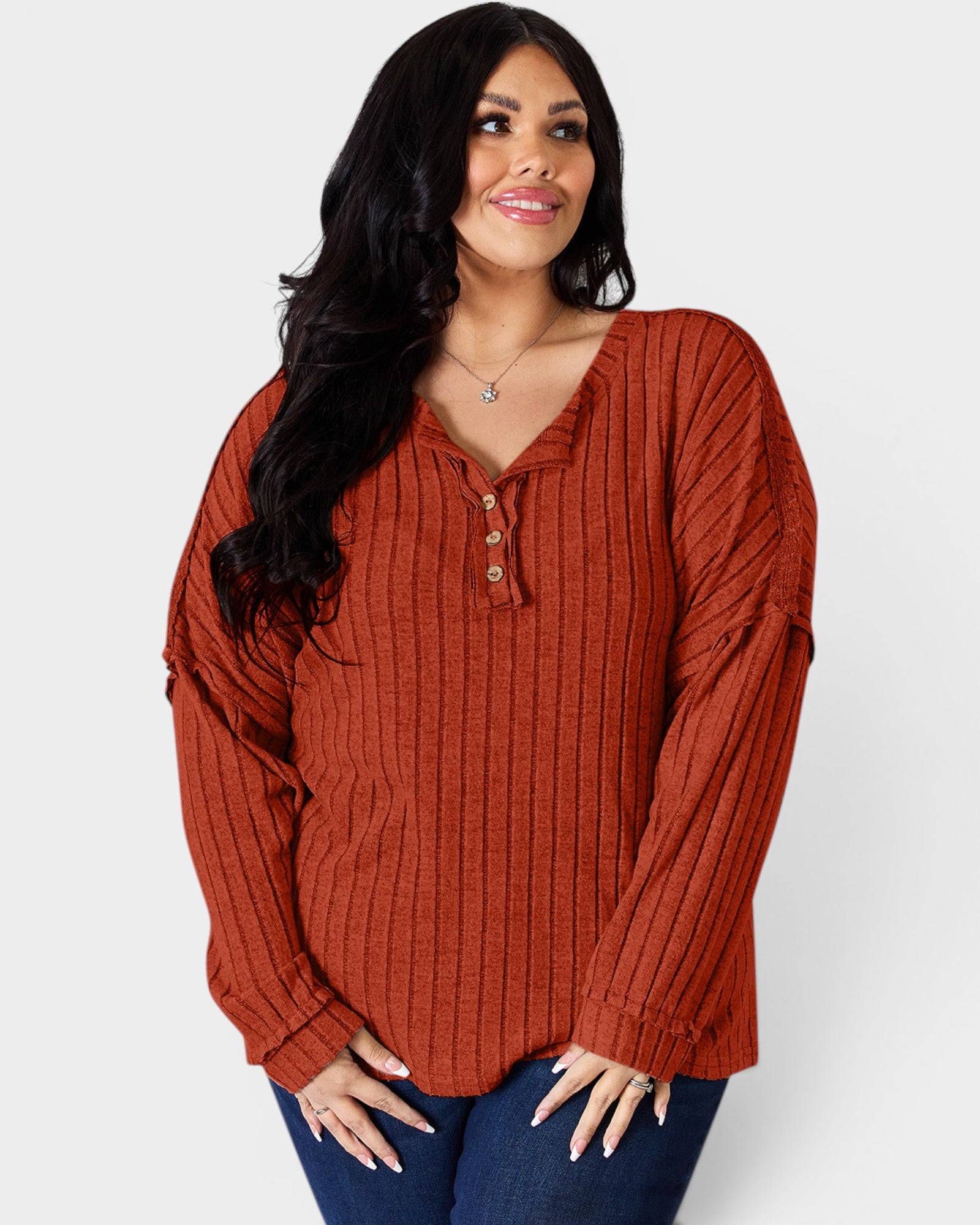 Woman wearing a rust-colored ribbed blouse against a white background