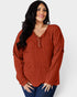 Woman wearing a rust-colored ribbed blouse against a white background