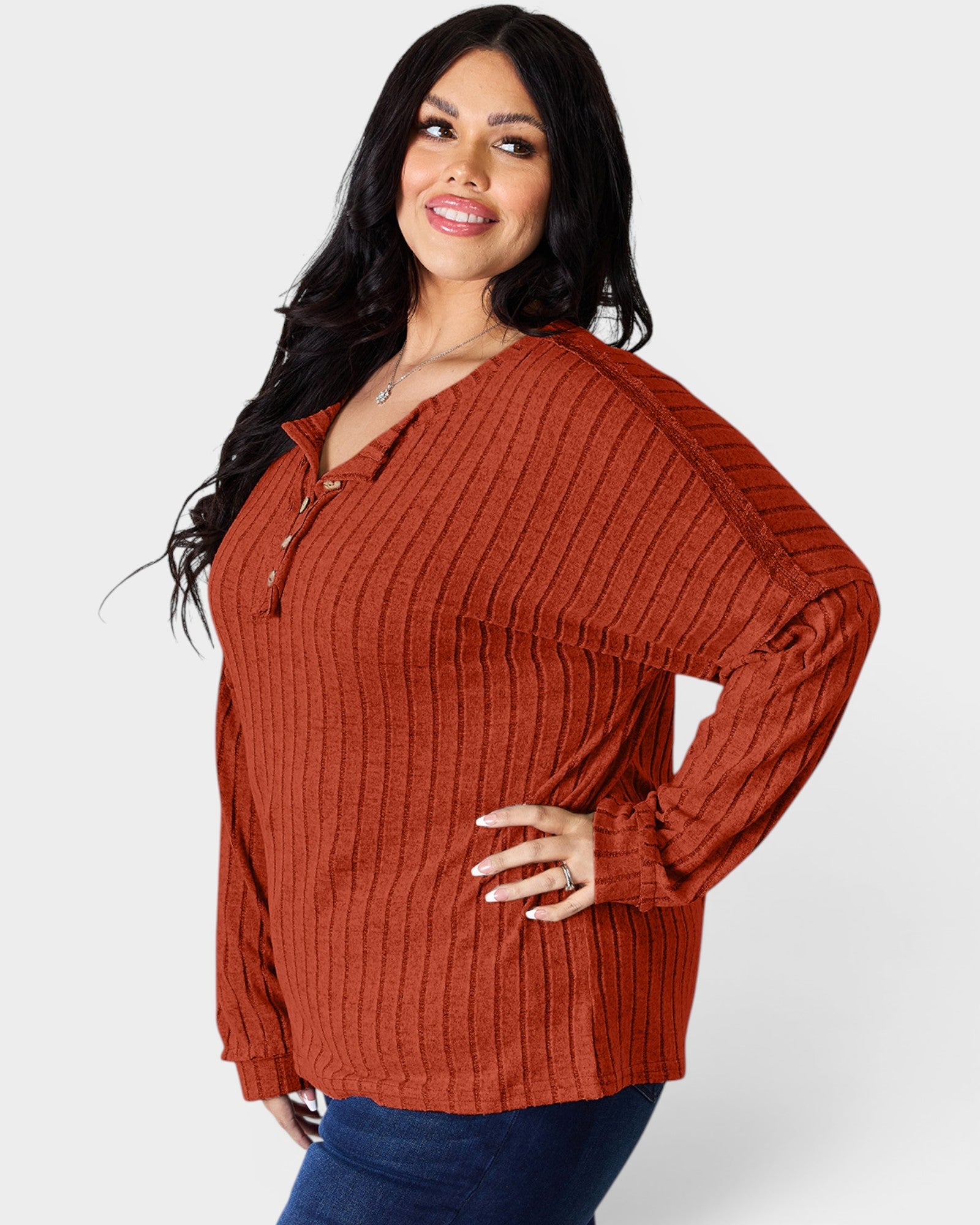 Woman wearing a rust-colored ribbed sweater on a white background