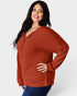 Woman wearing a rust-colored ribbed sweater on a white background