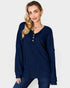 Woman wearing a blue ribbed sweater on a plain background