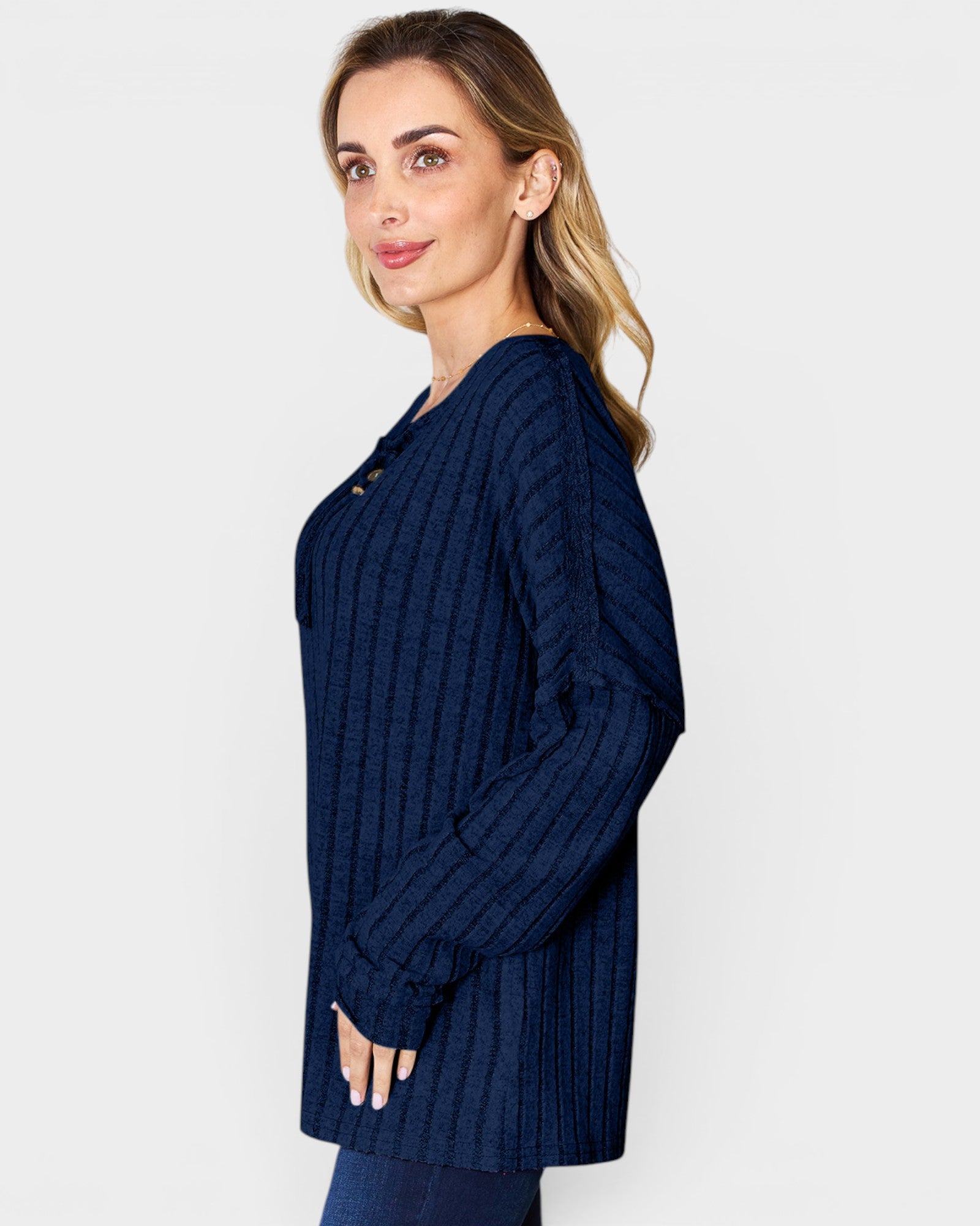 Woman wearing a navy blue ribbed sweater on a white background