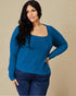 Woman wearing a blue ribbed sweater against a beige background