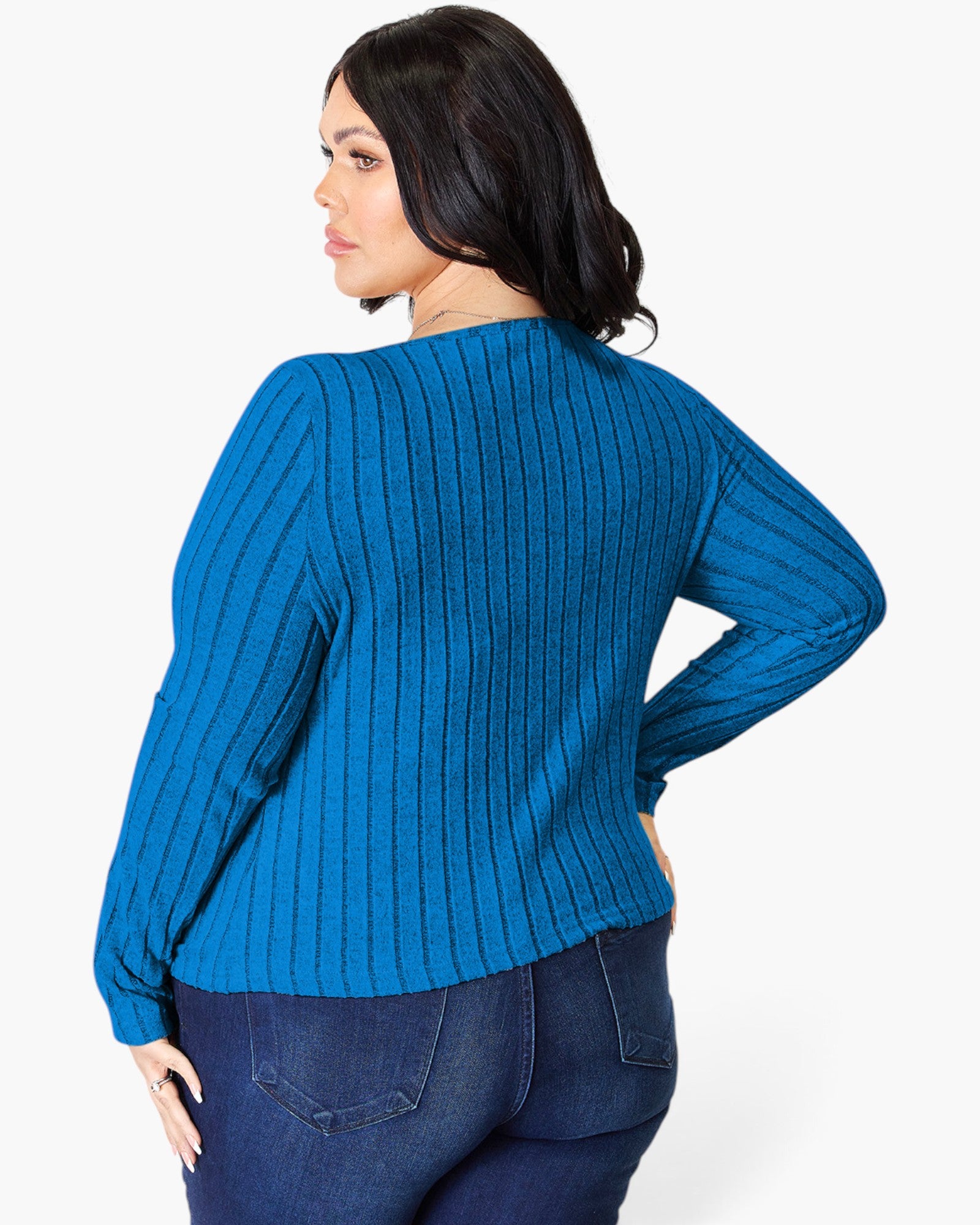 A woman wearing a bright blue ribbed knit sweater, shown from the back and side against a plain white studio background.