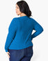 A woman wearing a bright blue ribbed knit sweater, shown from the back and side against a plain white studio background.