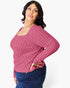 A woman modeling a ribbed long-sleeve scoop-neck sweater in dusty rose pink, paired with dark blue jeans, against a plain light gray background.