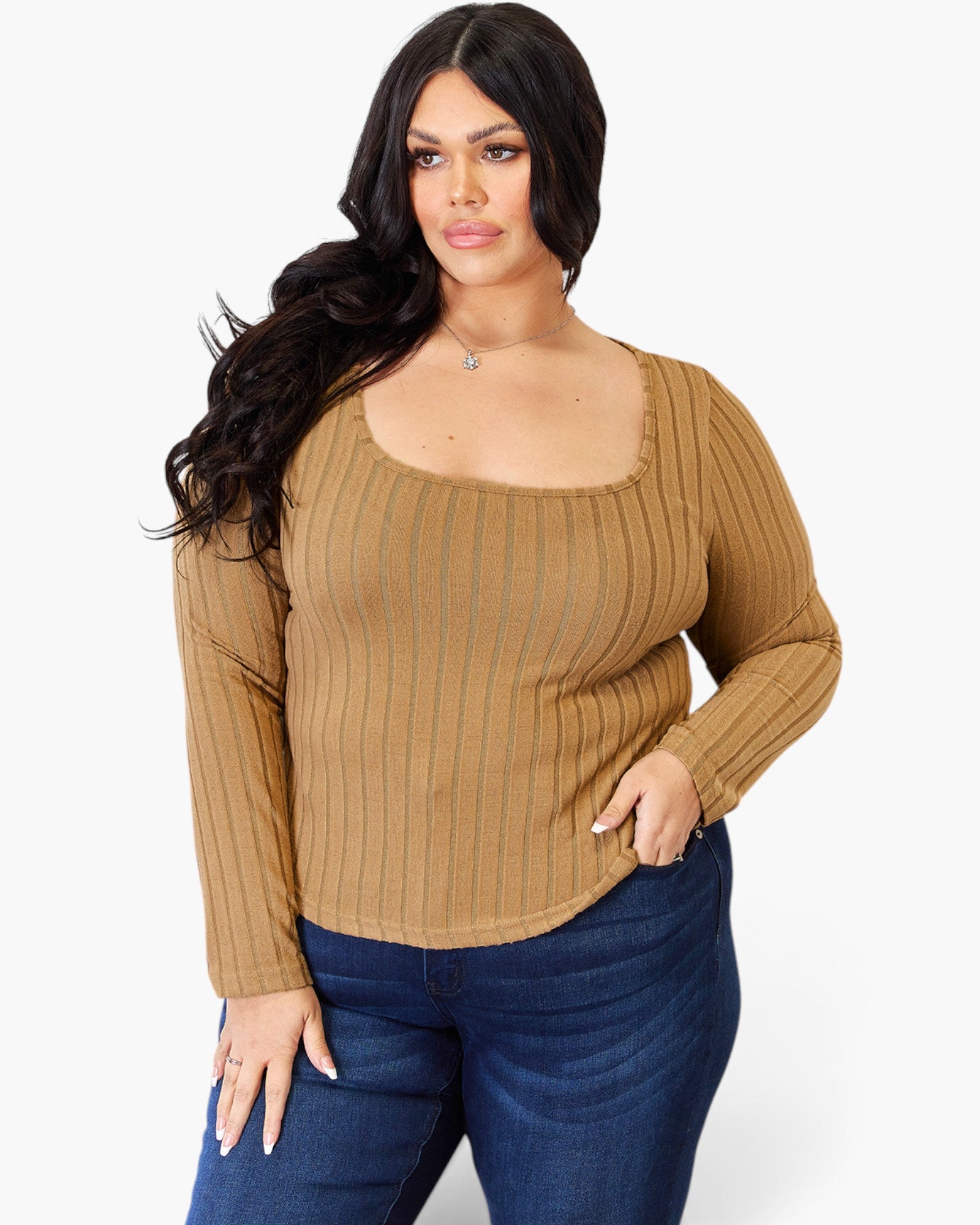 A woman modeling a tan ribbed long-sleeve top with a square neckline, paired with dark blue jeans, against a plain white background.