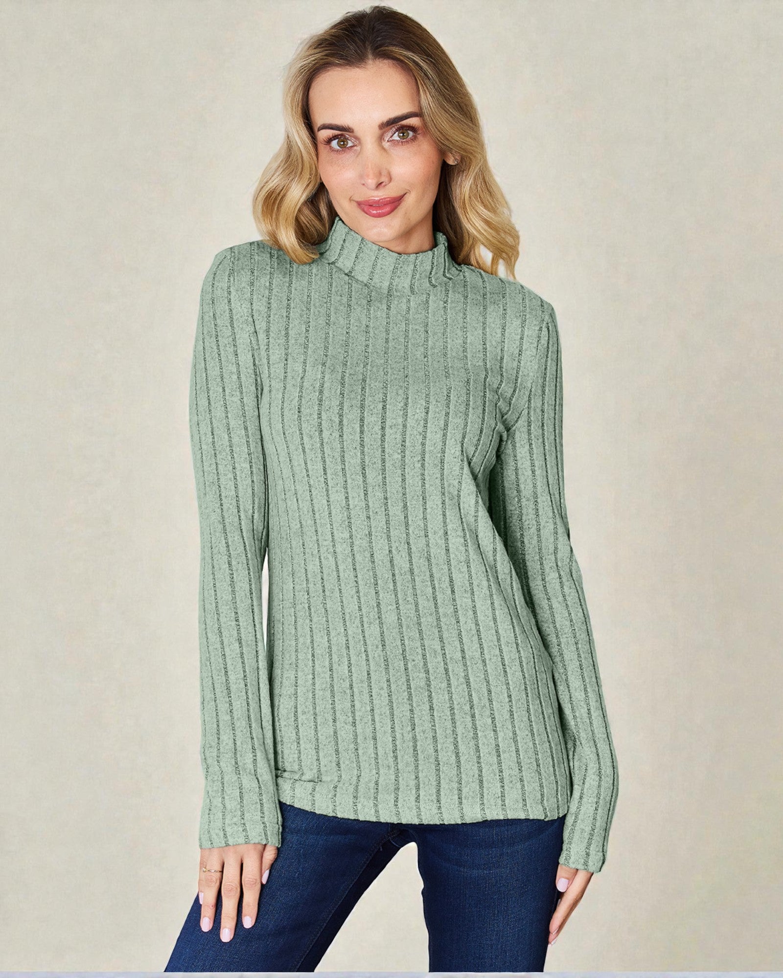 Woman wearing a green ribbed sweater against a beige background