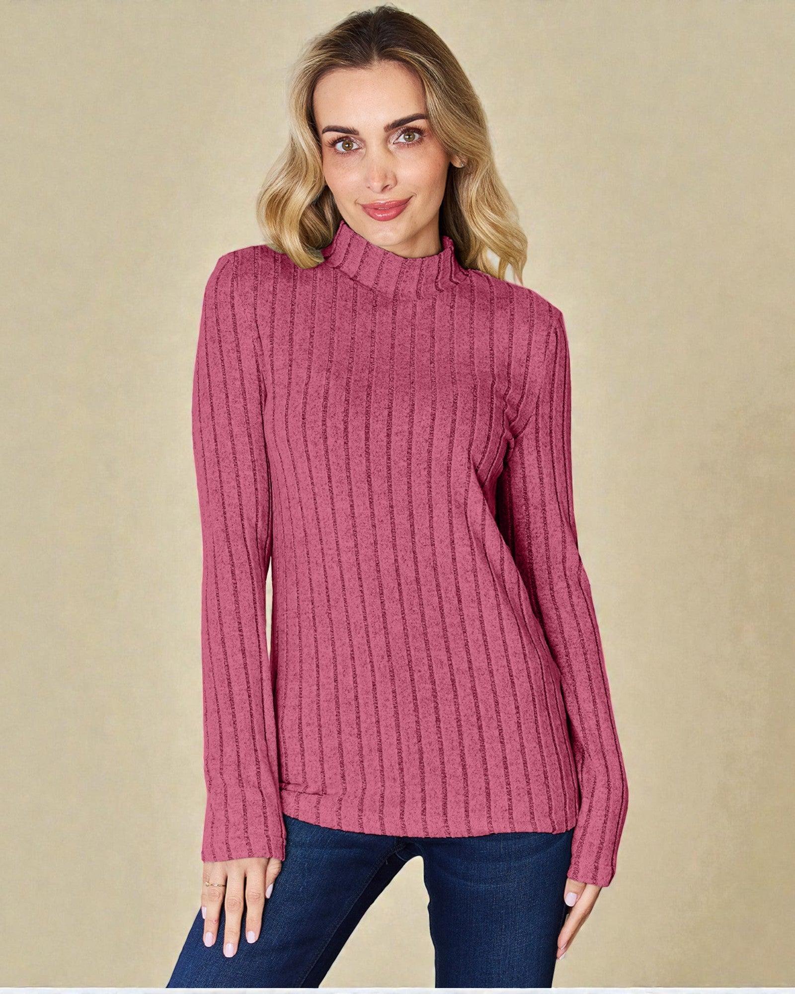 Woman wearing a pink ribbed sweater against a beige background