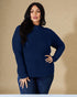 Woman wearing a blue ribbed sweater against a beige background
