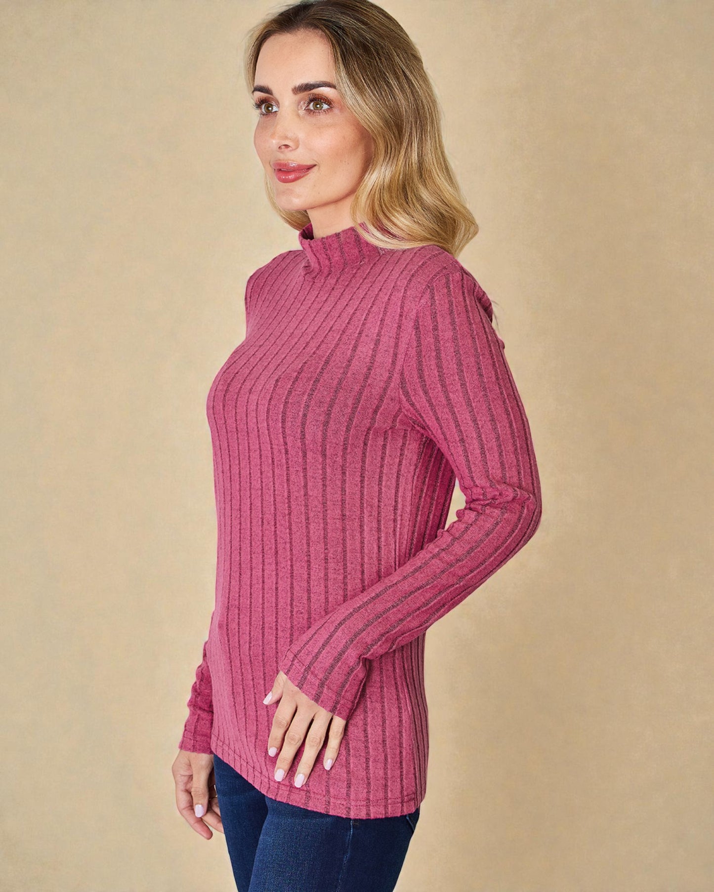 Woman wearing a pink ribbed sweater against a beige background