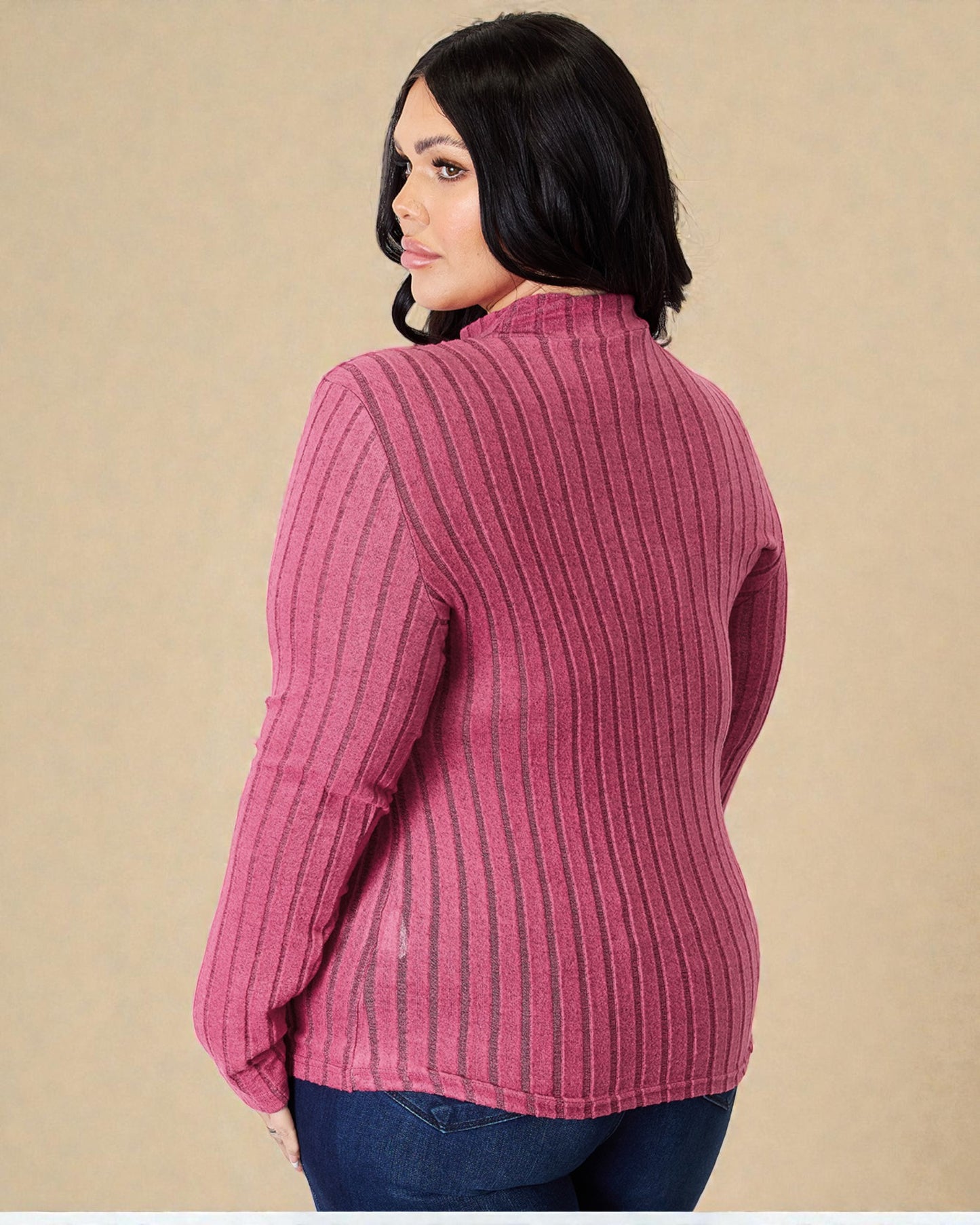 Woman wearing a pink ribbed sweater against a beige background