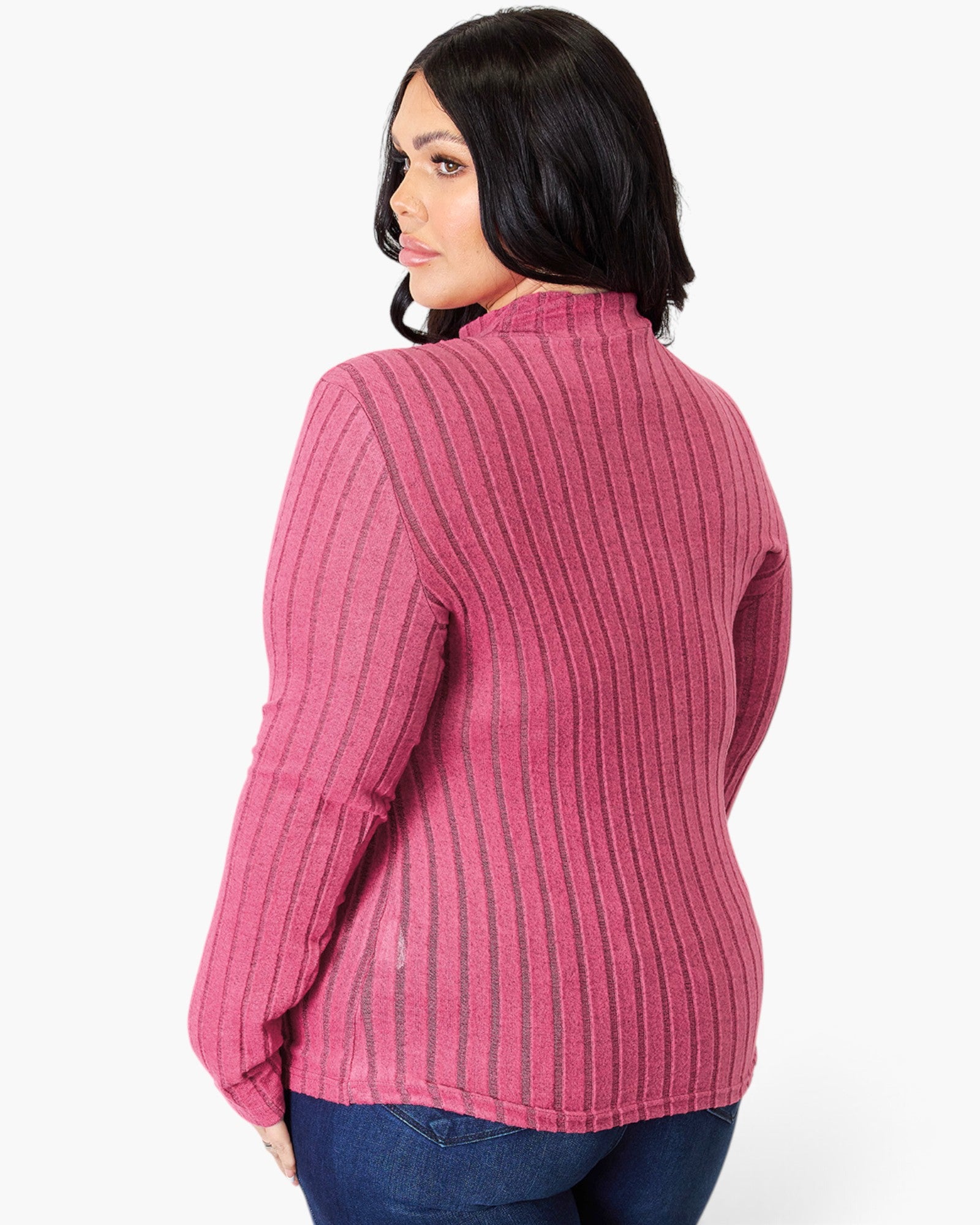 A woman shown from the back wearing a pink ribbed knit mock-neck sweater with dark blue jeans, against a plain white background.