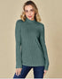 Woman wearing a green ribbed sweater against a beige background
