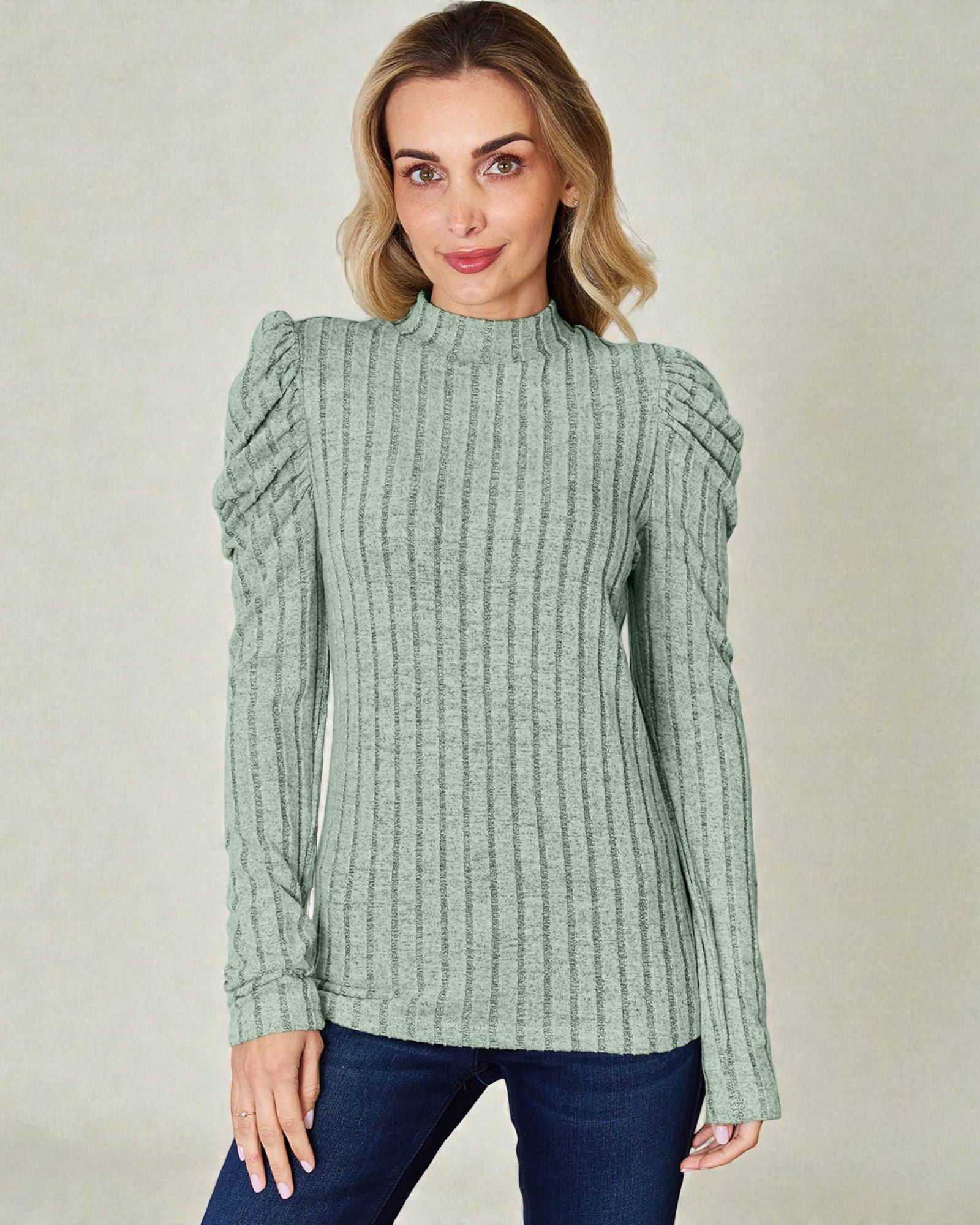 Woman wearing a green ribbed sweater against a plain background