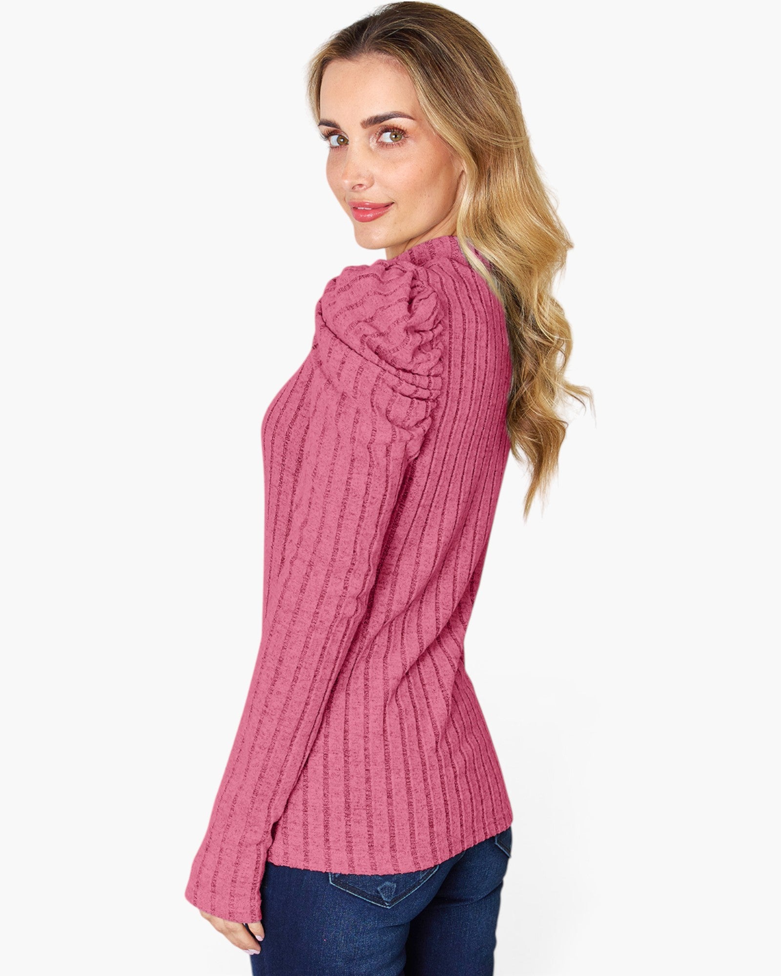 A woman wearing a pink ribbed knit sweater with a high ruffled collar, shown from a side-back angle against a plain white background.