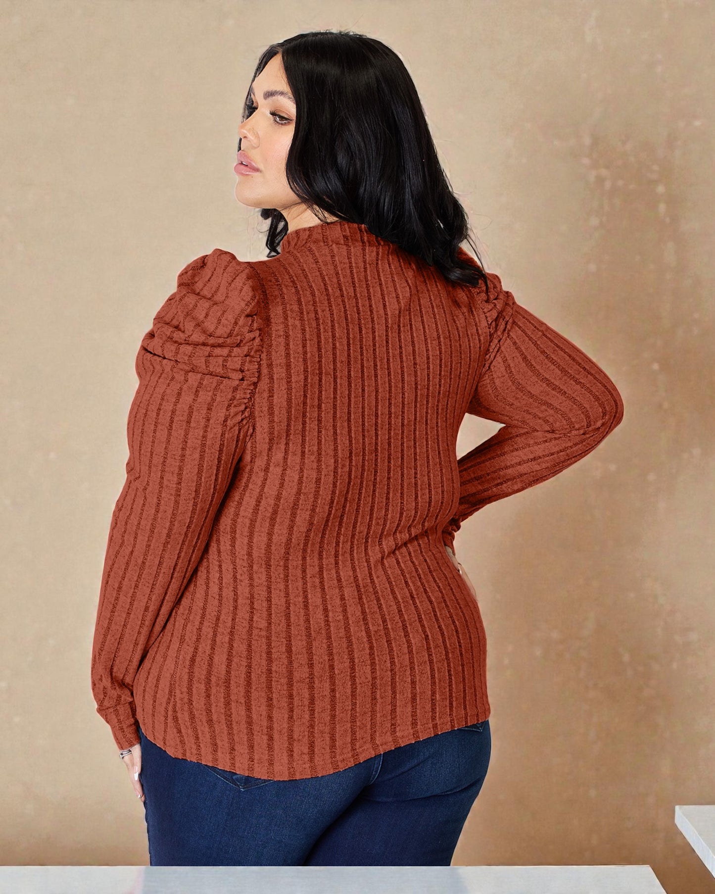 Woman wearing a rust-colored ribbed sweater against a beige background