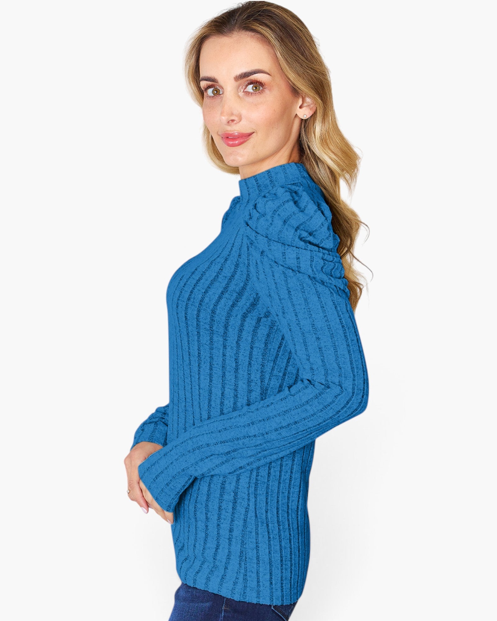 A woman wearing a bright blue ribbed knit mock neck sweater, shown from a side profile against a plain white background.