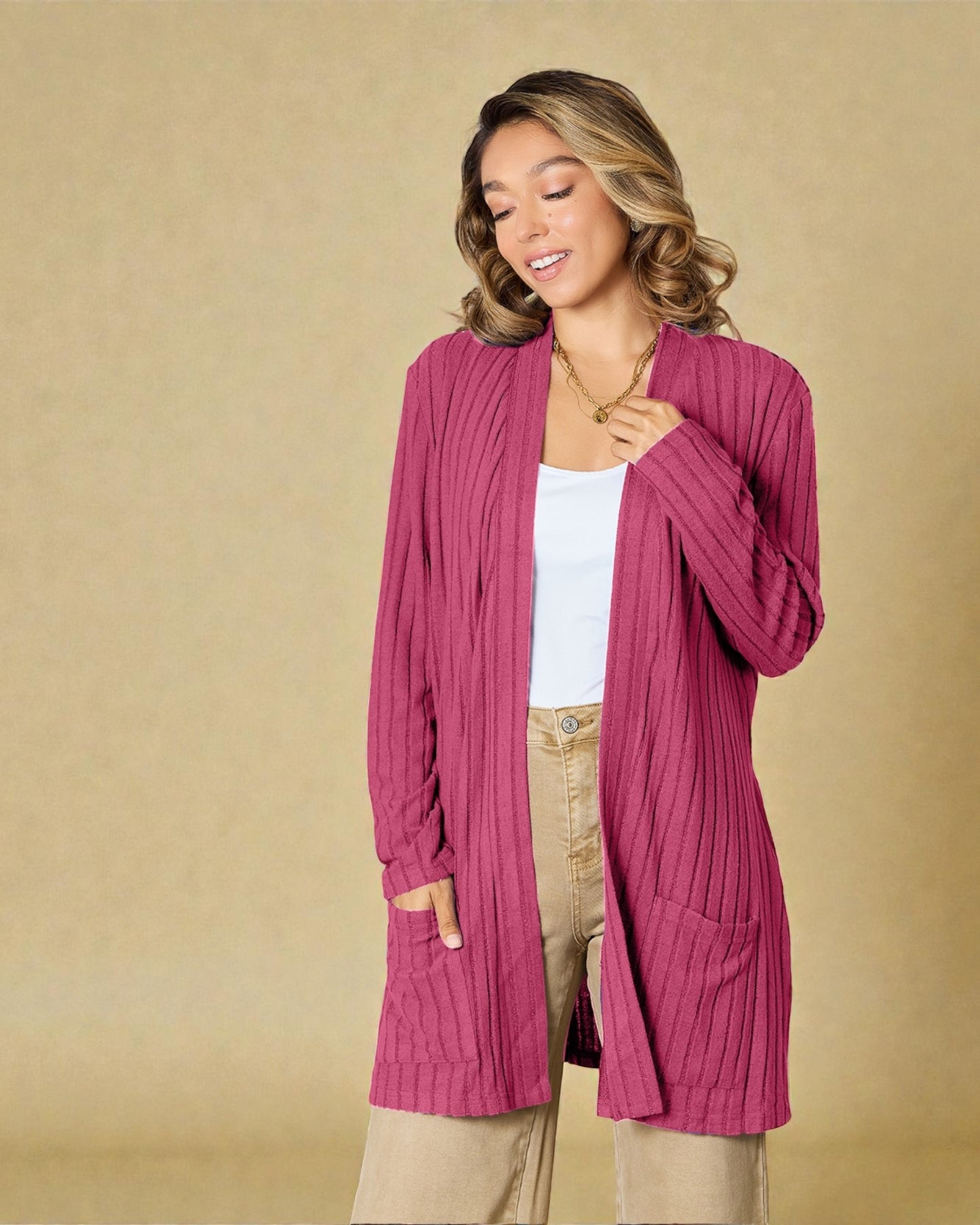 Woman wearing a pink cardigan against a beige background