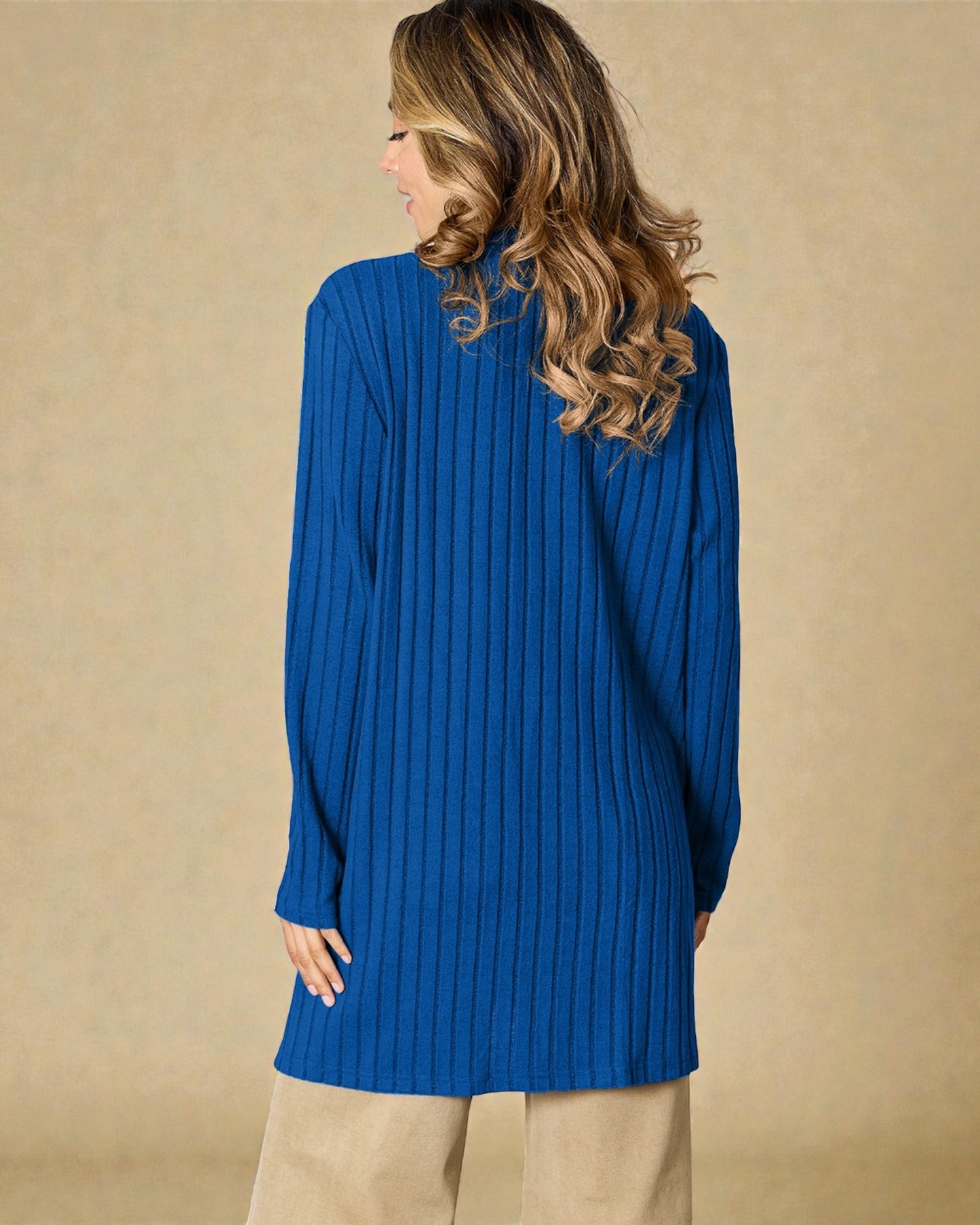 Woman wearing a blue ribbed sweater against a beige background