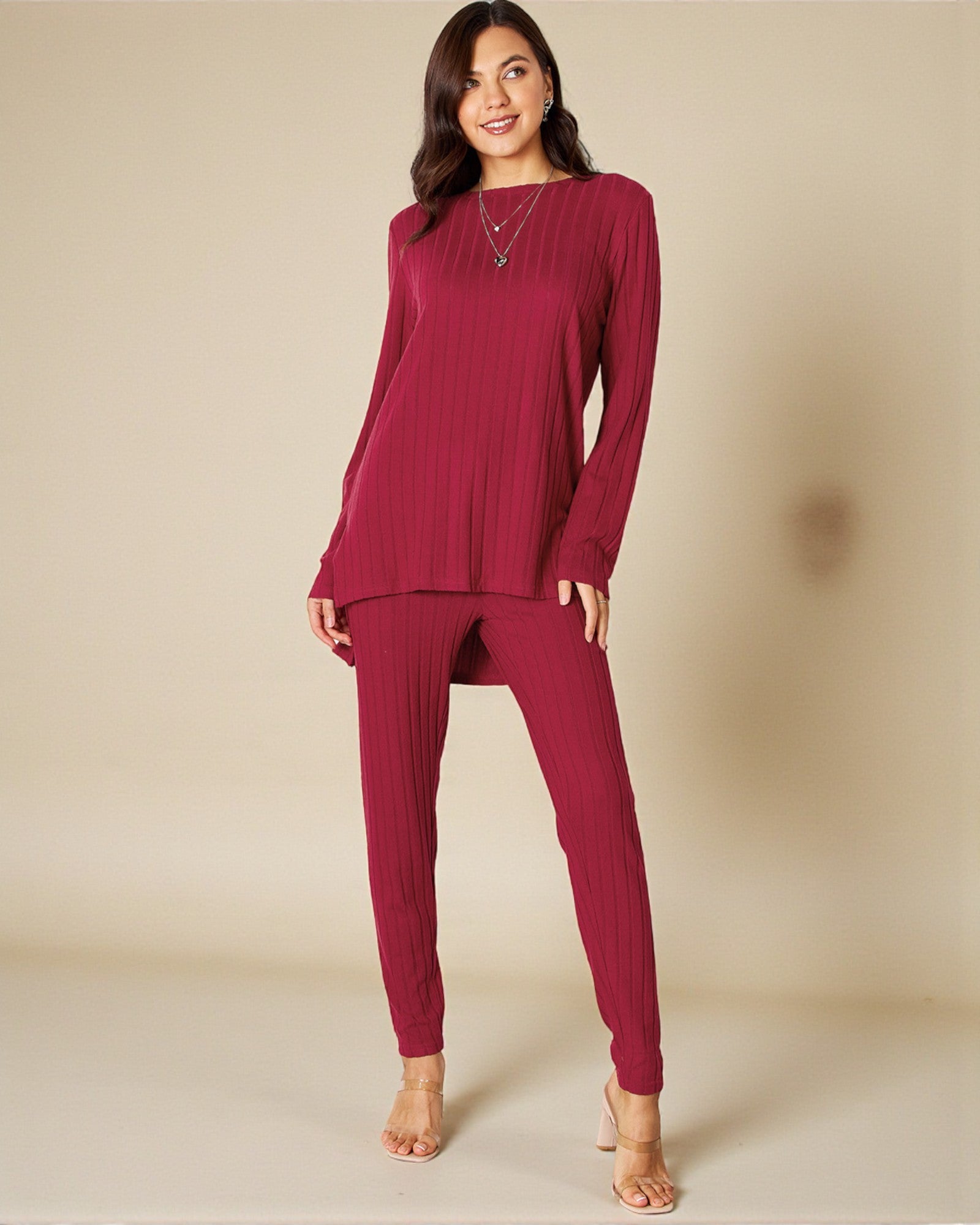 Woman wearing a burgundy long-sleeve top and pants on a beige background