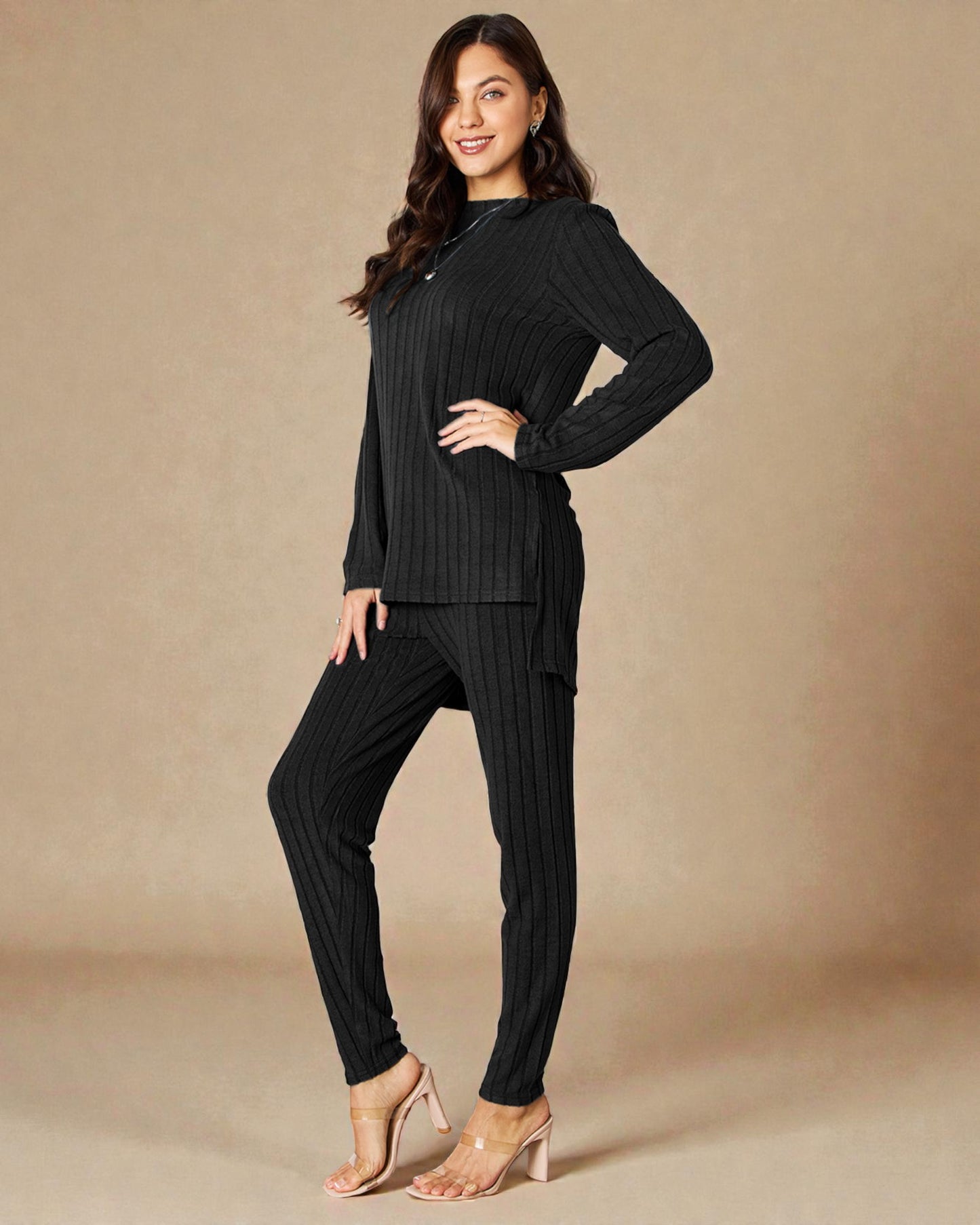 Woman wearing a black ribbed sweater and pants on a beige background