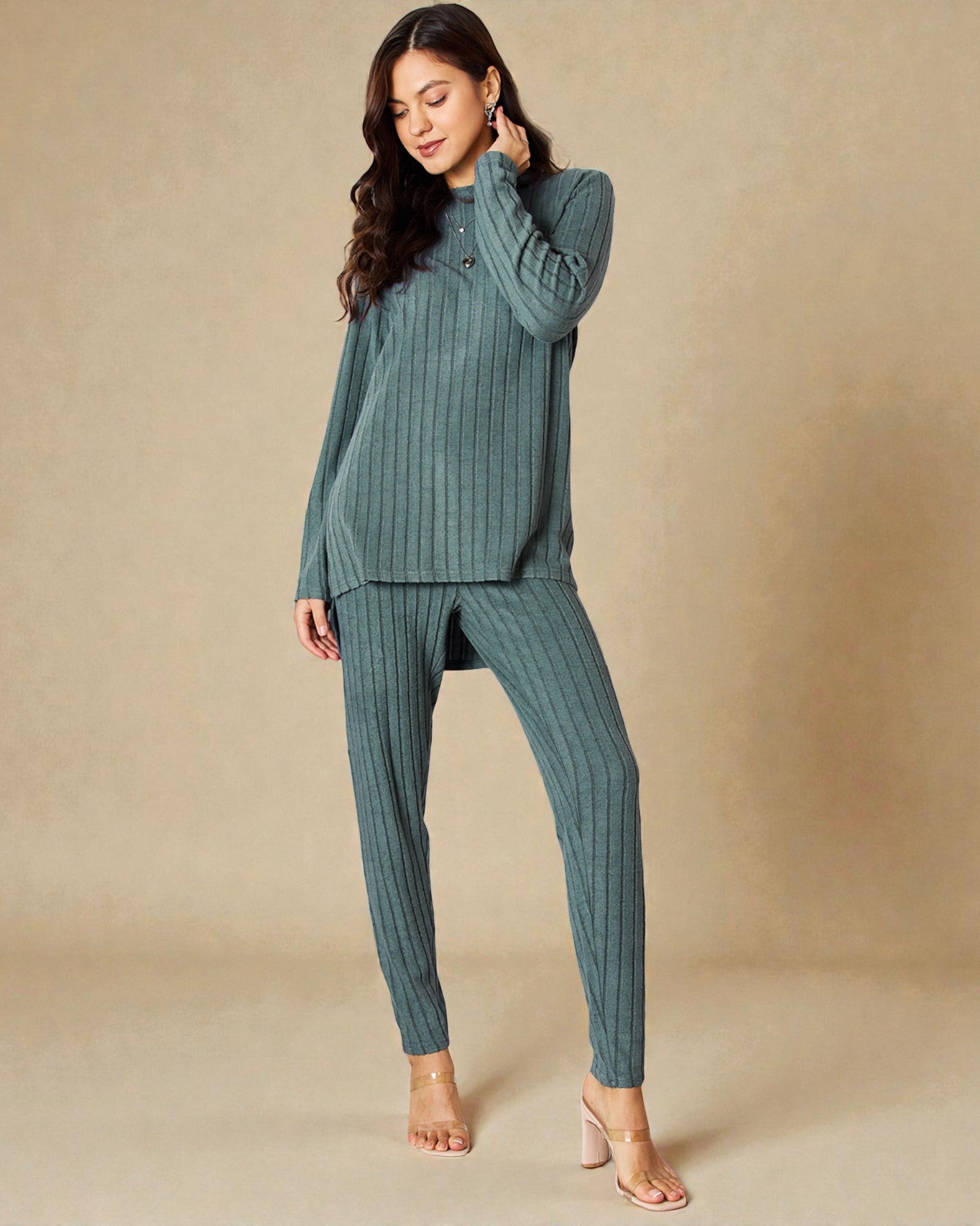 Woman wearing a green ribbed lounge set against a beige background