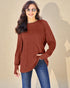 Woman wearing a brown ribbed sweater and blue jeans against a beige background