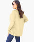 A woman wearing a light yellow ribbed knit long-sleeve top and blue jeans, photographed from the back against a plain white background.