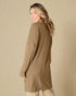 Woman wearing a brown ribbed cardigan against a beige background