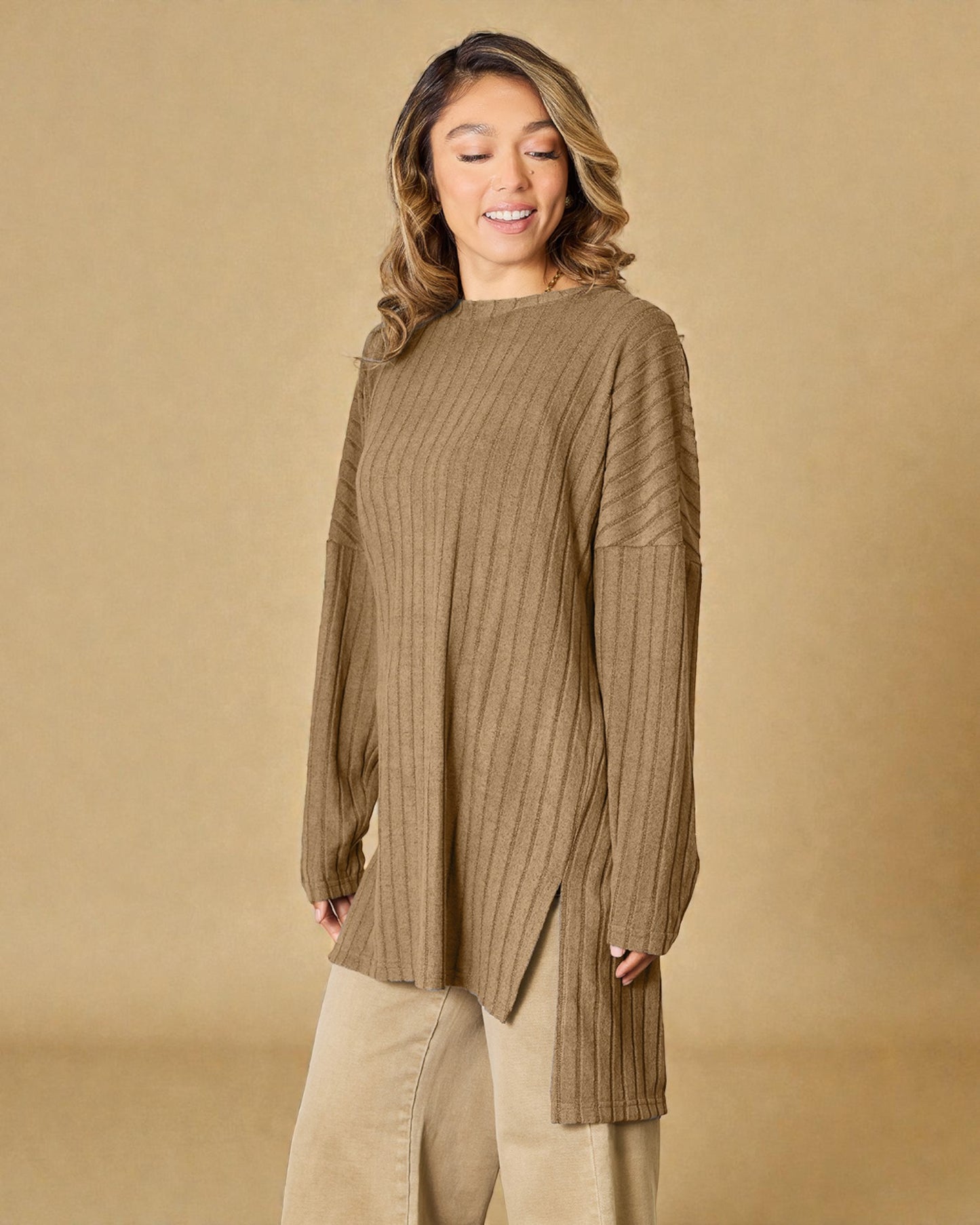 Woman wearing a ribbed brown sweater against a beige background