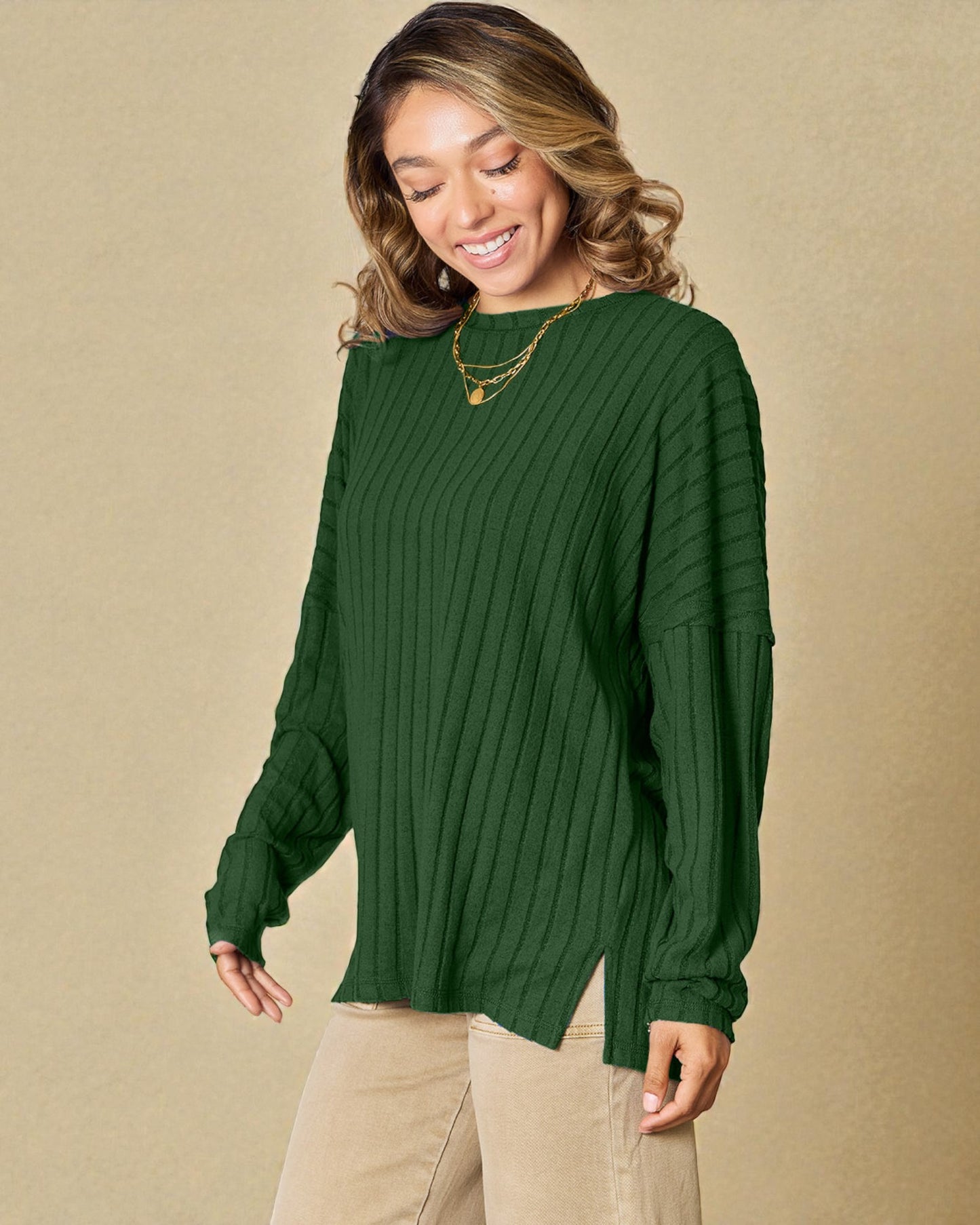 Woman wearing a green sweater against a beige background