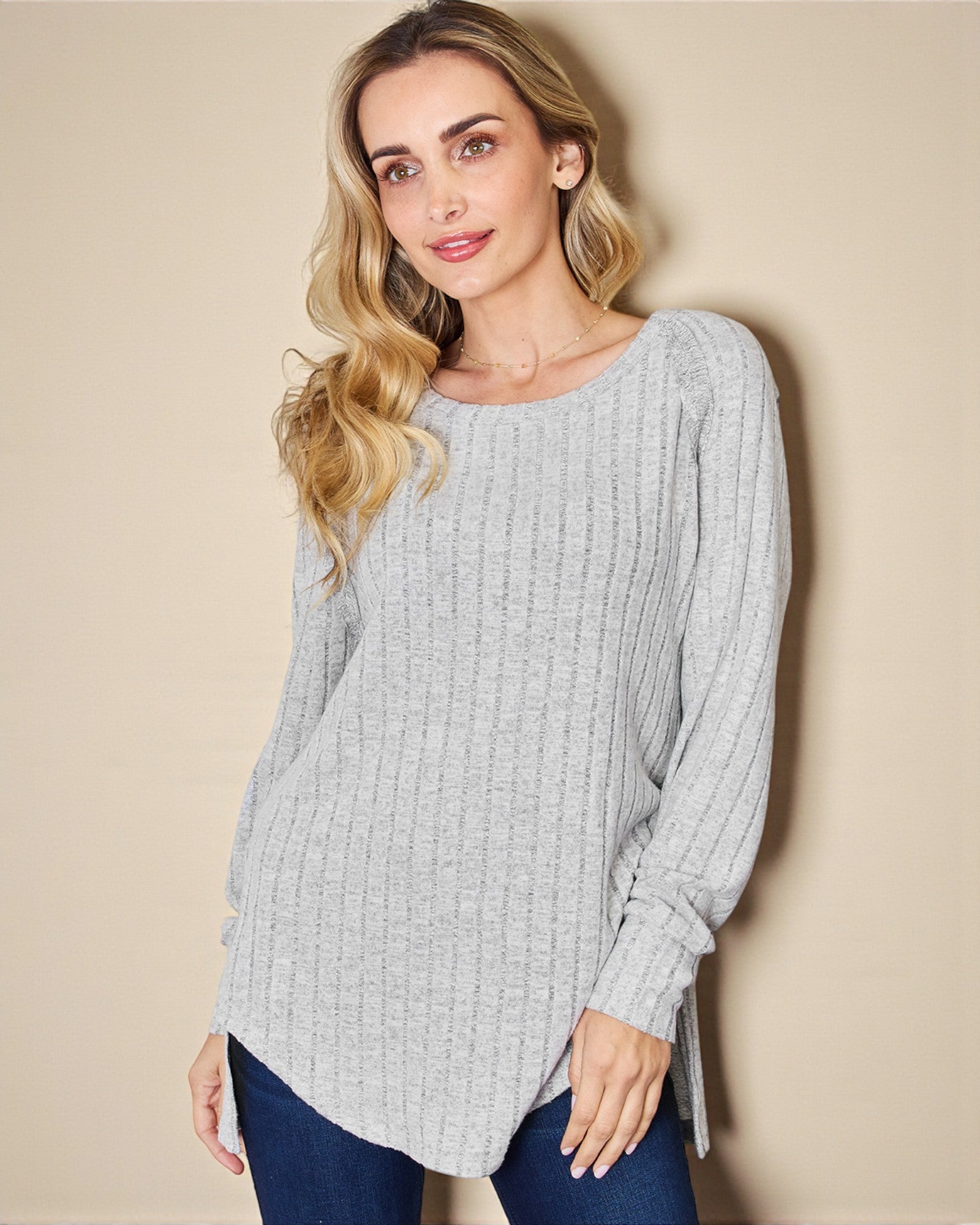 Woman wearing a light gray sweater against a beige background
