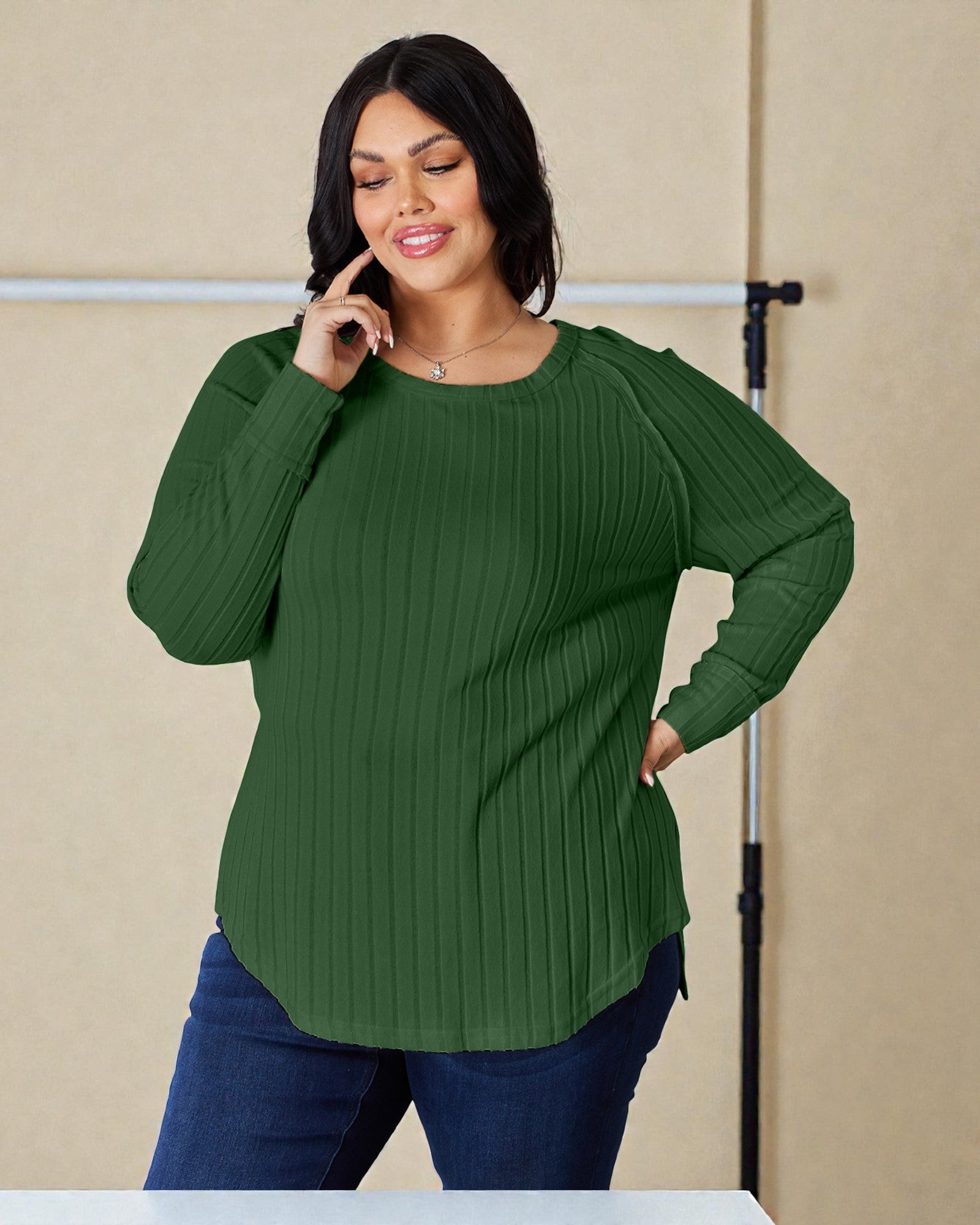 Woman wearing a green ribbed sweater against a beige background